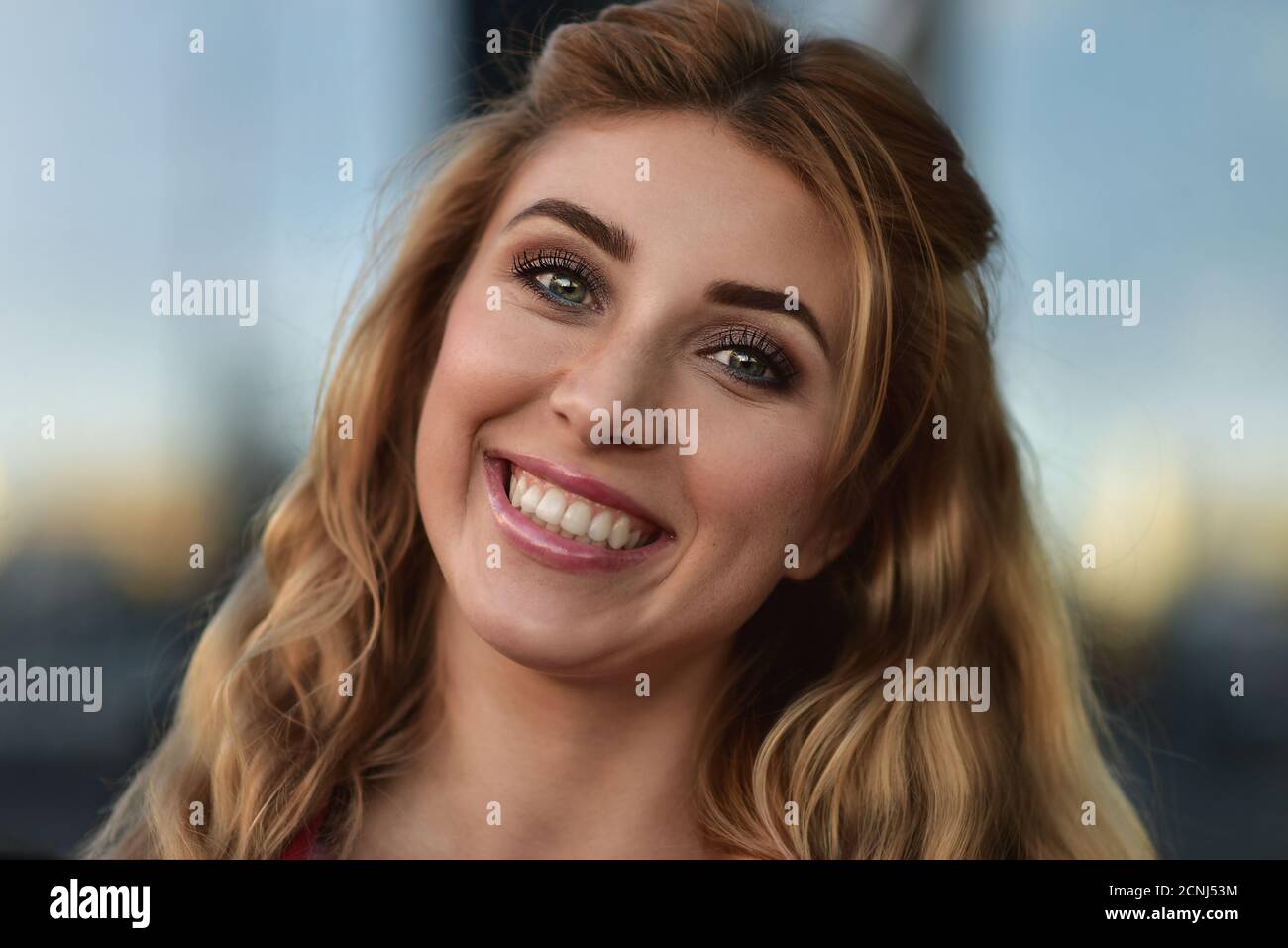 Gros plan portrait d'une belle fille souriante avec de belles dents à l'extérieur dans la rue. Banque D'Images