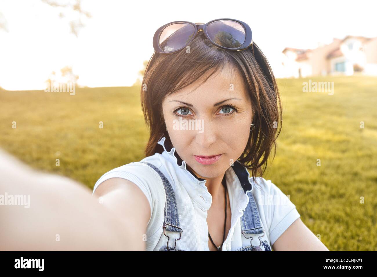 Femme caucasienne adulte dans la nature, prenant le selfie et marchant dans le parc du soir . concept selfie Banque D'Images