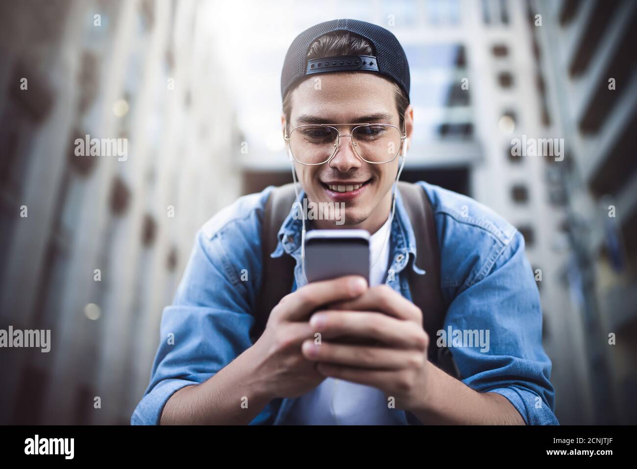 Un homme heureux qui écoute de la musique avec un casque depuis un smartphone o Banque D'Images