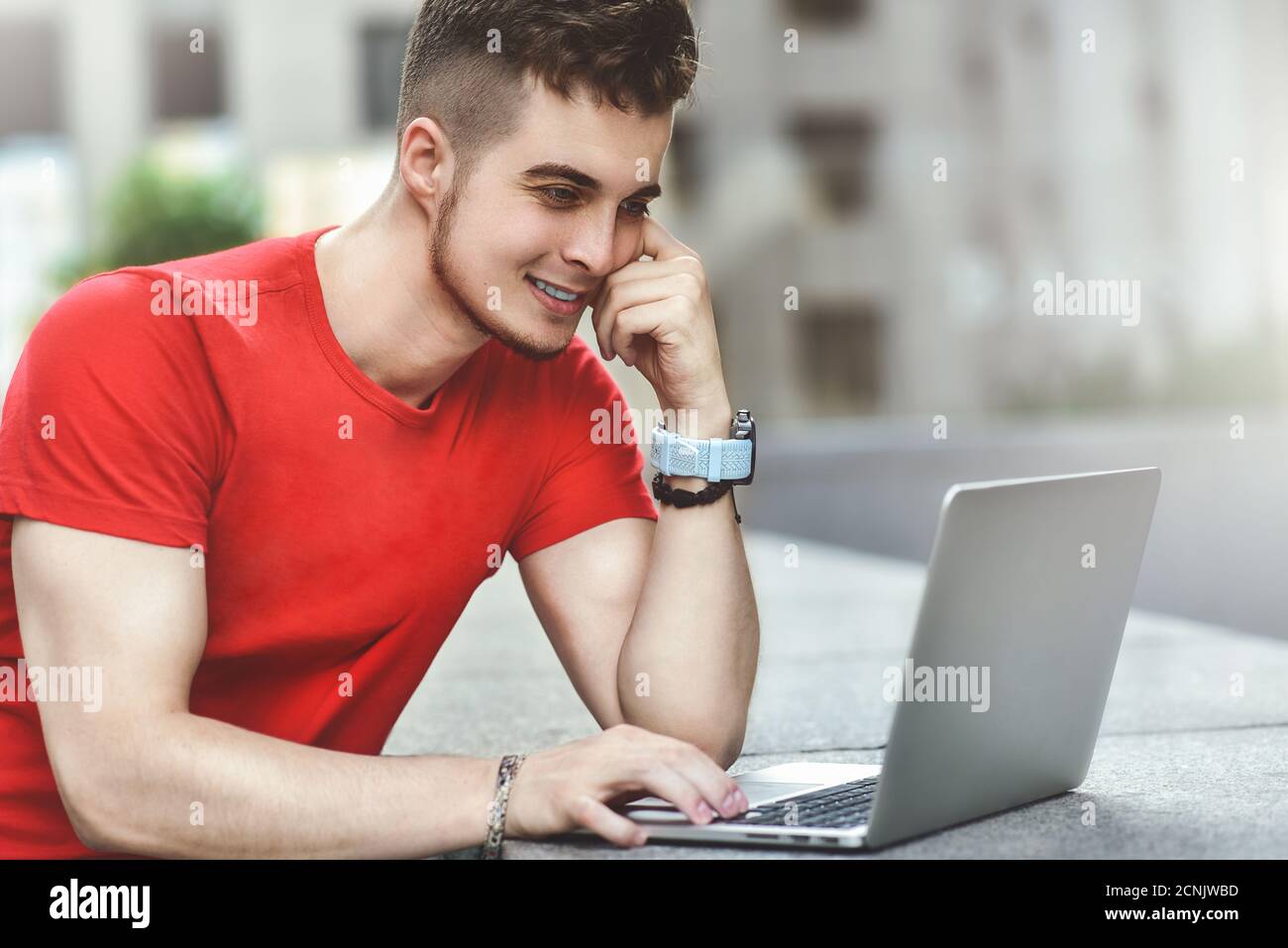 Jeune homme caucasien pensif utilisant un ordinateur portable pour discuter en ligne. Banque D'Images