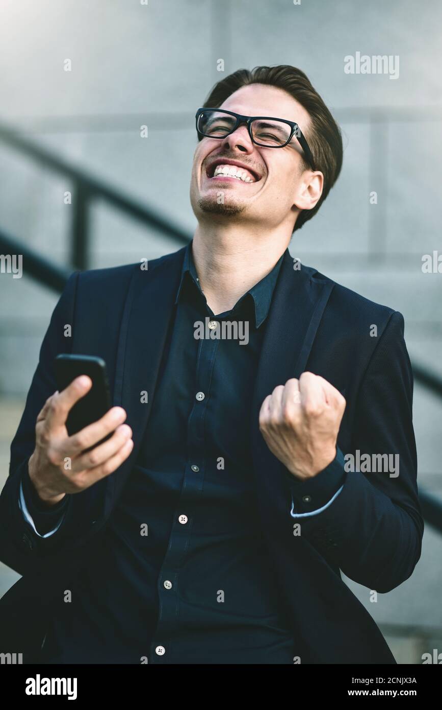 Un homme d'affaires de bonne nouvelle a obtenu de bonnes nouvelles par téléphone debout dans la rue. Banque D'Images