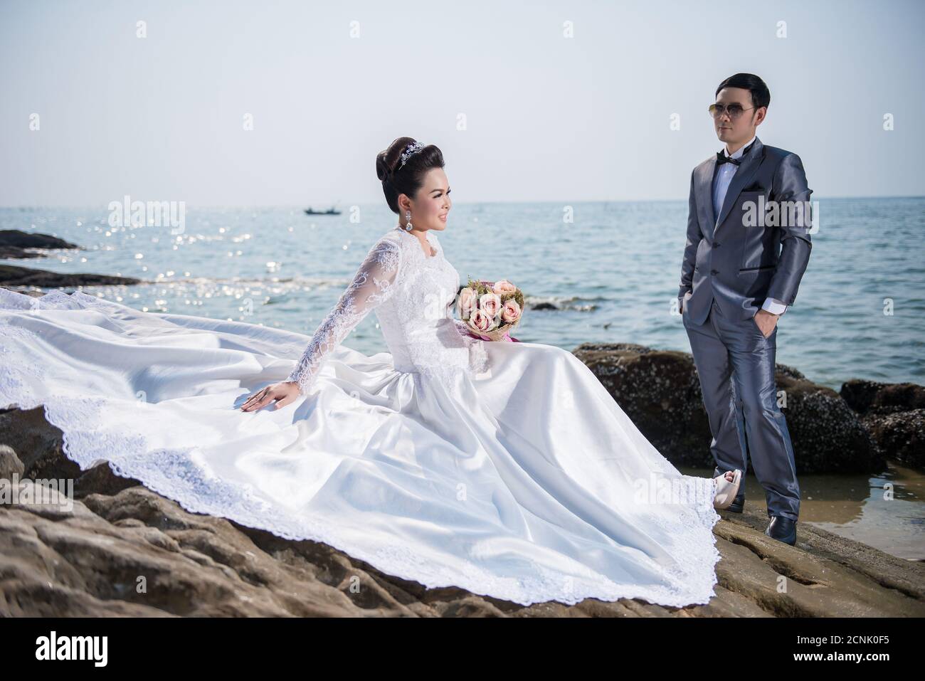 Couple asiatique portant une robe de mariage et un costume pour la  cérémonie de mariage sur la plage. Couple sur la plage concept. Robe de  mariée blanche Photo Stock - Alamy