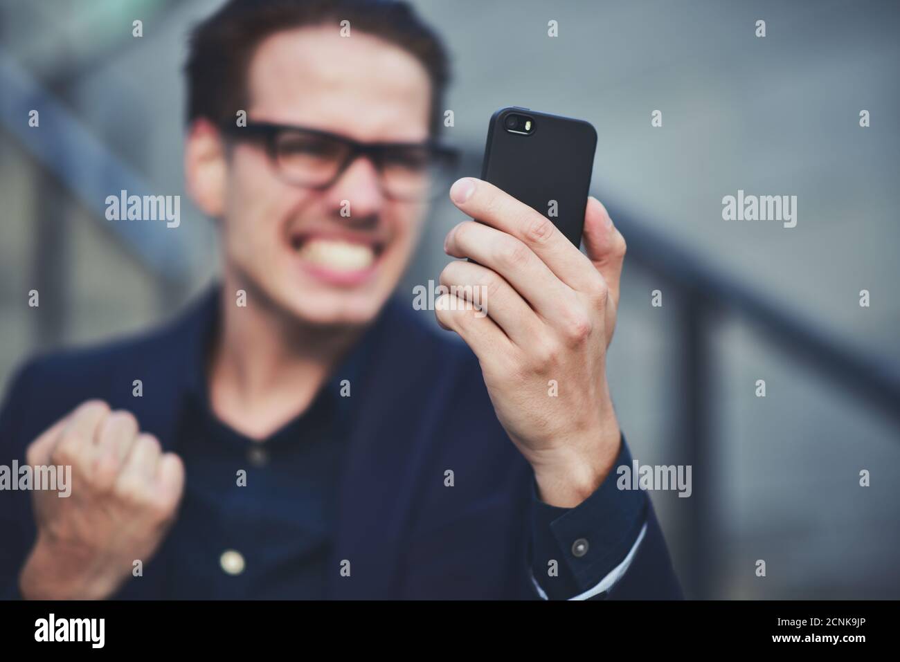 Un homme d'affaires de bonne nouvelle a obtenu de bonnes nouvelles par téléphone debout dans la rue. Banque D'Images