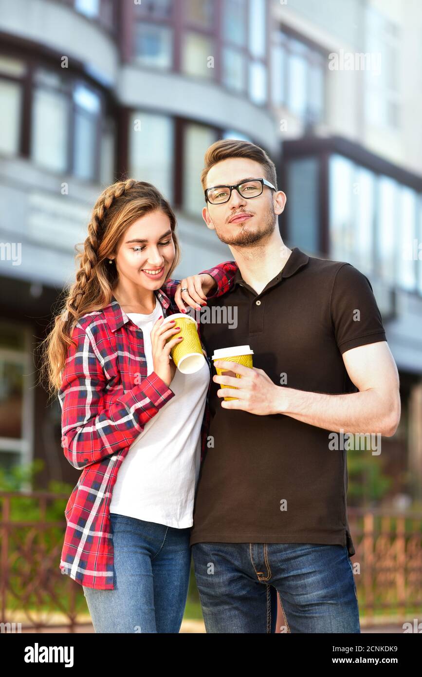 Magnifique couple en train de marcher dans la rue et boire un café Banque D'Images