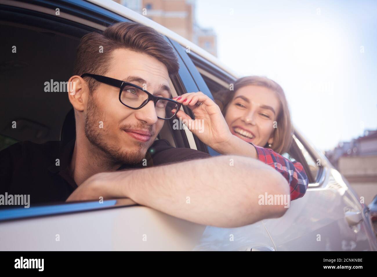 Jeune couple caucasien en voiture ayant du plaisir sur la route Banque D'Images
