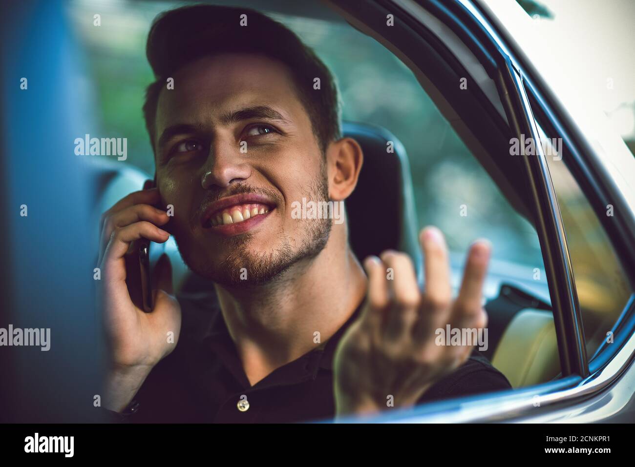 Homme d'utiliser un smartphone dans le siège arrière de la voiture. Banque D'Images