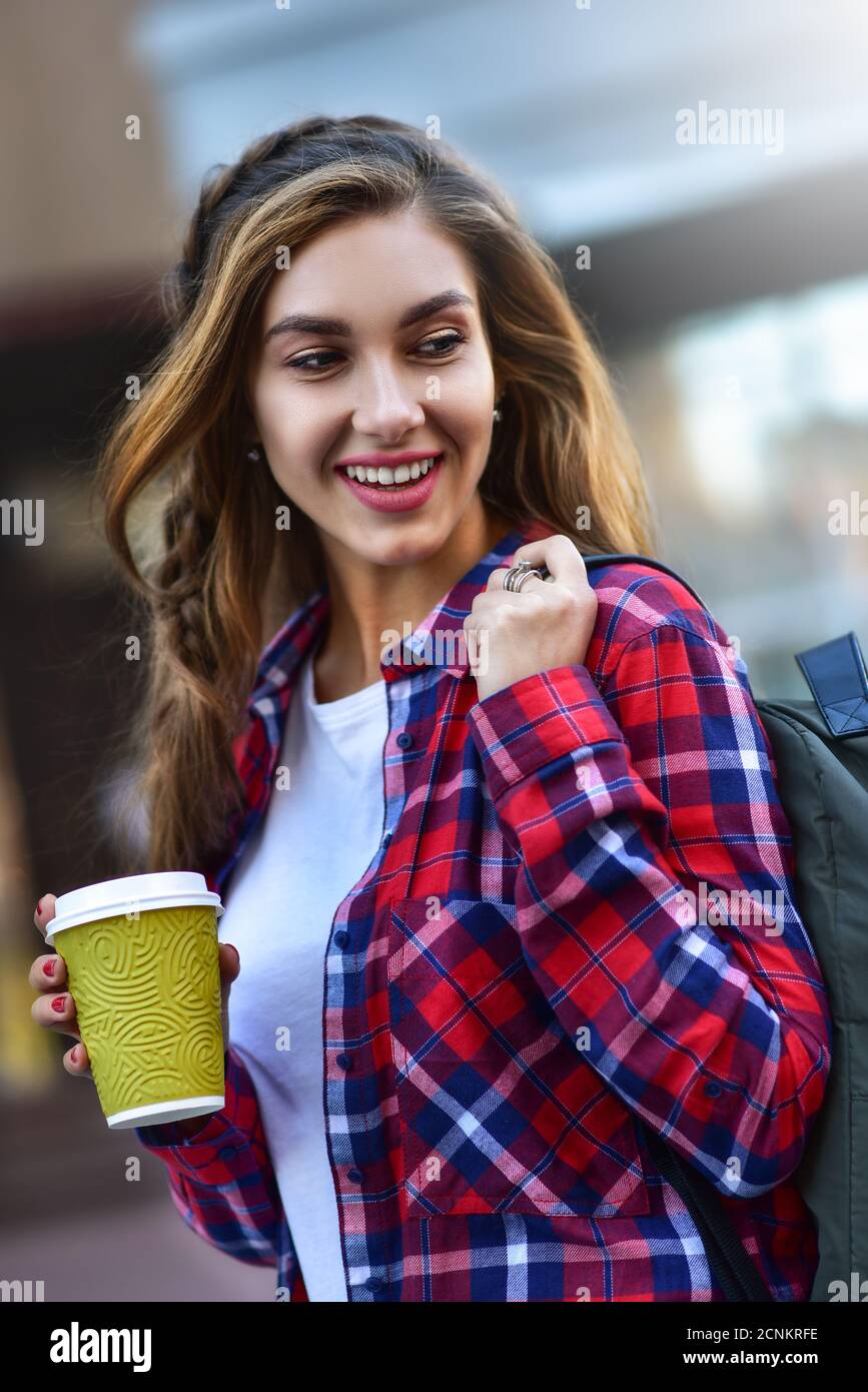 Belle fille qui marche dans la rue avec du café. Banque D'Images