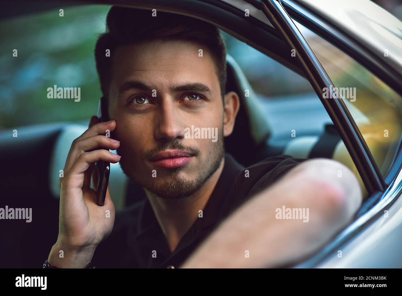 Homme d'utiliser un smartphone dans le siège arrière de la voiture. Banque D'Images