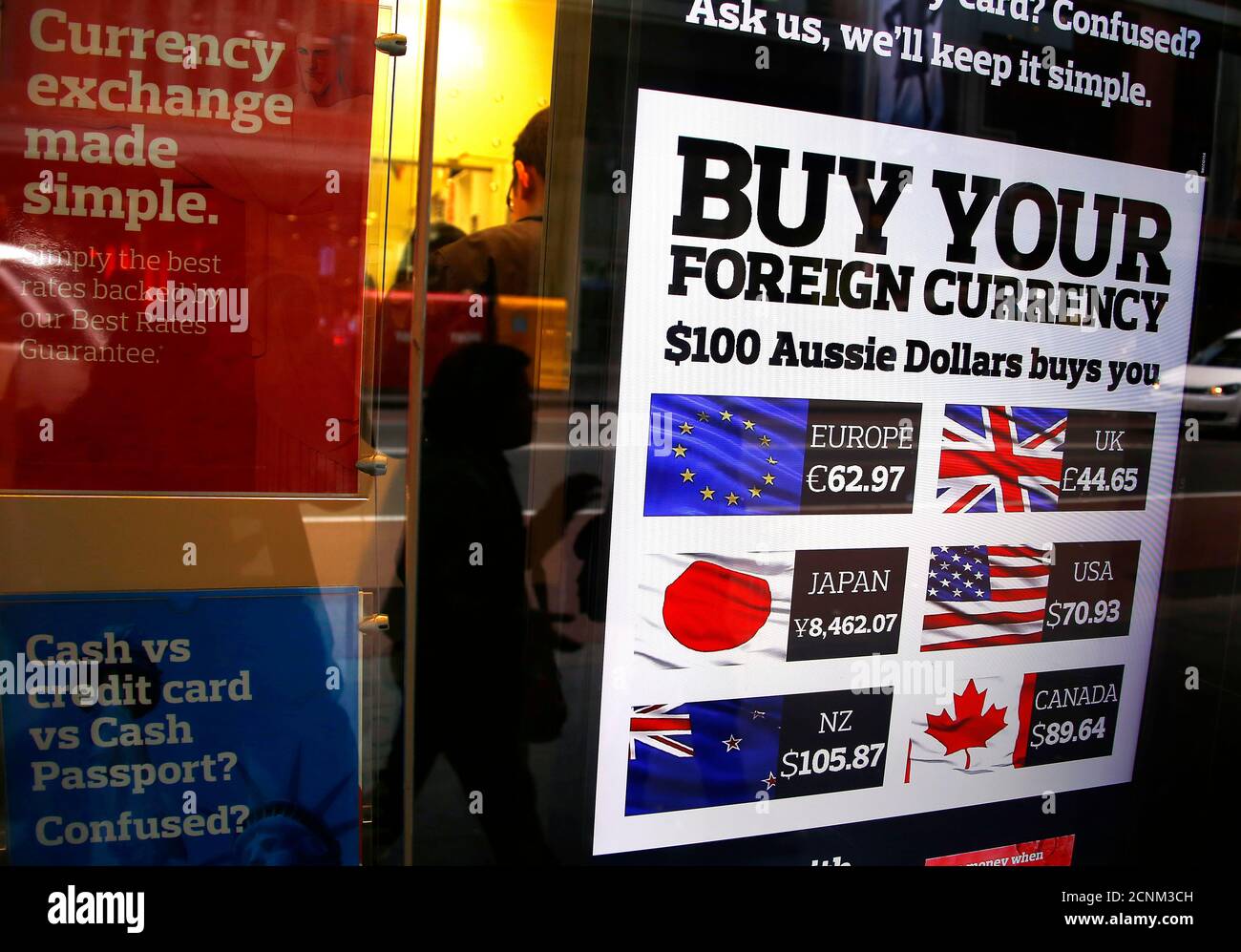 Un piéton se reflète dans la fenêtre d'un magasin de change, qui affiche  une carte avec des valeurs en dollars australiens, dans le centre de  Sydney, en Australie, le 12 août 2015.