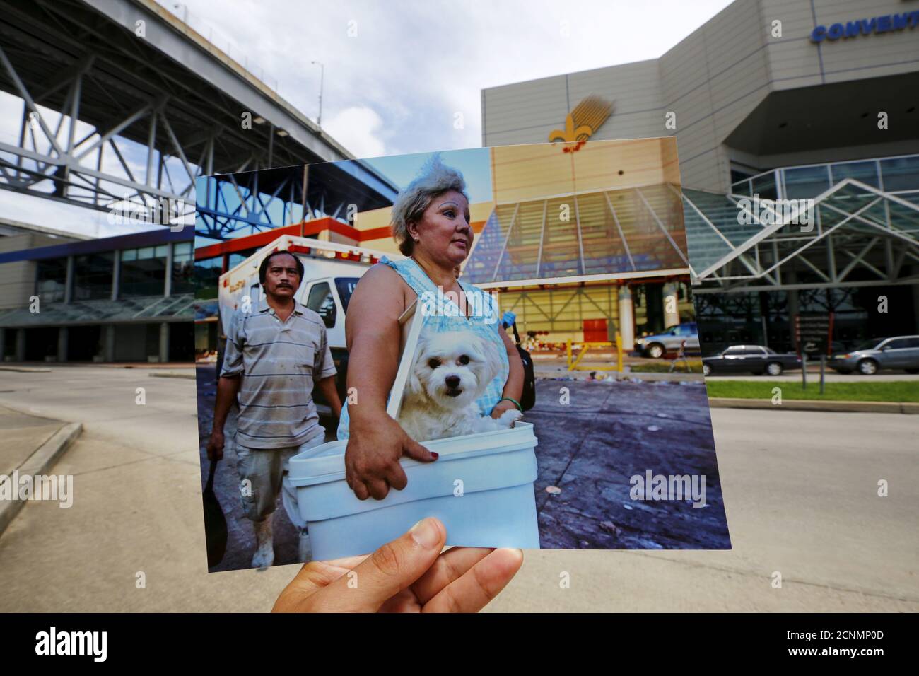 Le photographe Carlos Barria détient une copie d'une photo qu'il a prise en 2005, car il la compare au même endroit 10 ans plus tard, à la Nouvelle-Orléans, États-Unis, le 17 août 2015. L'imprimé montre une femme arrivant avec son chien à un point de collecte pour les victimes de l'ouragan Katrina, le 8 septembre 2005. En 2005, l'ouragan Katrina a déclenché des inondations qui ont inondé la Nouvelle-Orléans et tué plus de 1,500 personnes alors que les eaux pluviales ont submergé les digues et se sont rompues par les murs d'inondation. Le Congrès a autorisé à dépenser plus de 14 milliards de dollars pour renforcer la protection contre les inondations de la ville après Katrina et a construit une série de nouveaux bars Banque D'Images
