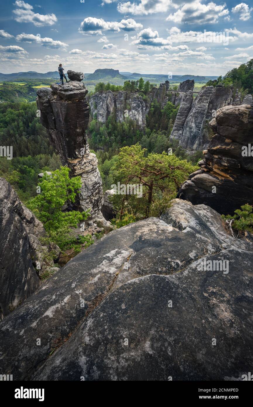 Grimpeur de silhouette non reconnu sur le sommet de montagne appréciant la célèbre formation de roche Bastei du parc national Saxon Suisse, Allemagne. Saison de printemps active Banque D'Images