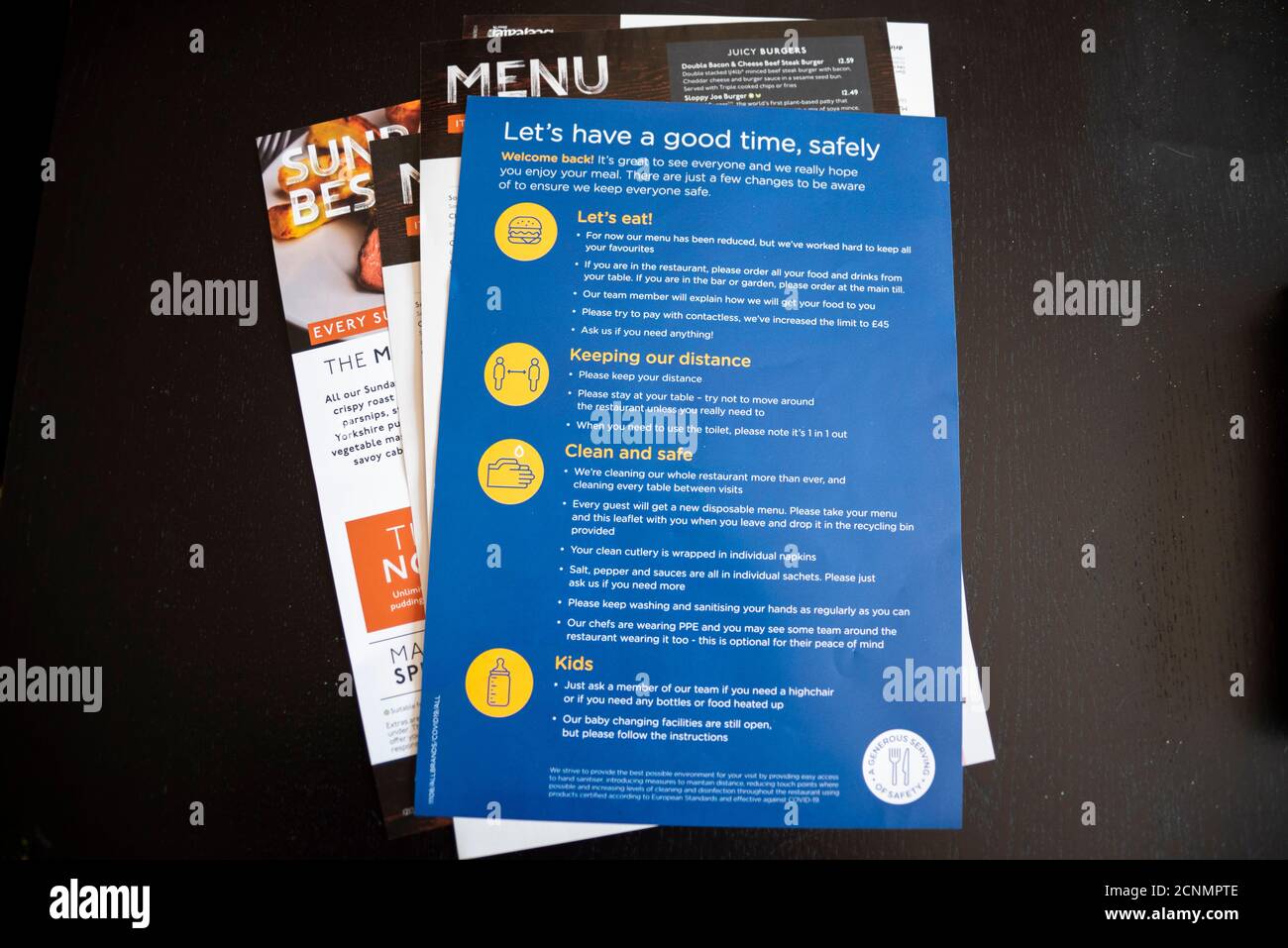 Précautions de sécurité du restaurant COVID 19 à la table. Accueil de l'industrie de retour, avec un usage unique, menu jetable et des instructions. Manger dehors Banque D'Images