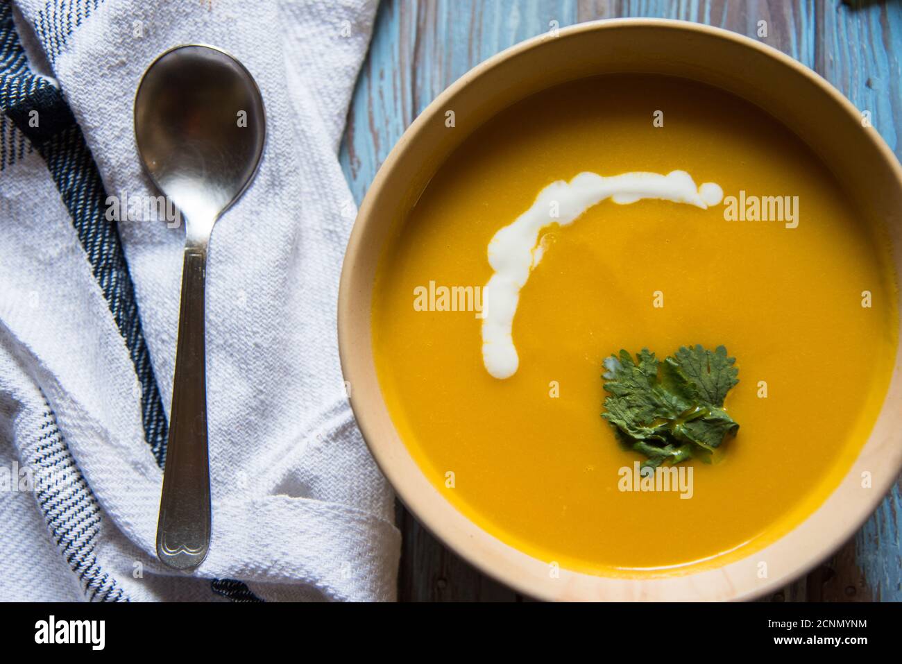 Soupe de potiron et feuille de persil dans un bol sur un arrière-plan Banque D'Images