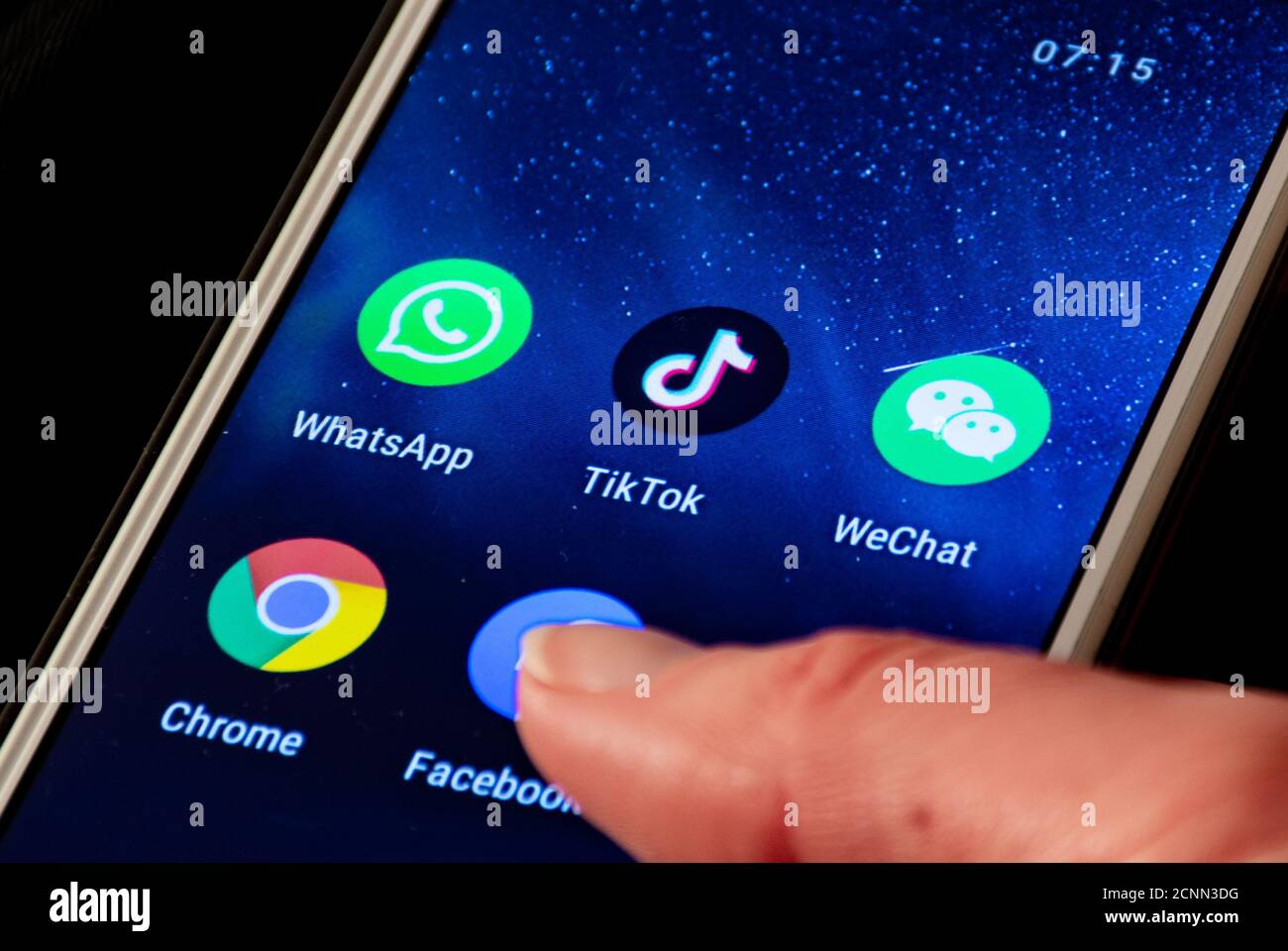 Gros plan du logo TikTok et WeChat, icône d'application affichée sur un smartphone avec le doigt, Trump interdit et bloqué Banque D'Images