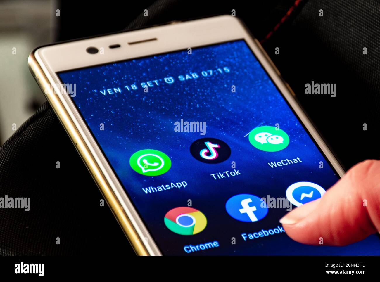 Gros plan du logo TikTok et WeChat, icône d'application affichée sur un smartphone avec le doigt, Trump interdit et bloqué Banque D'Images