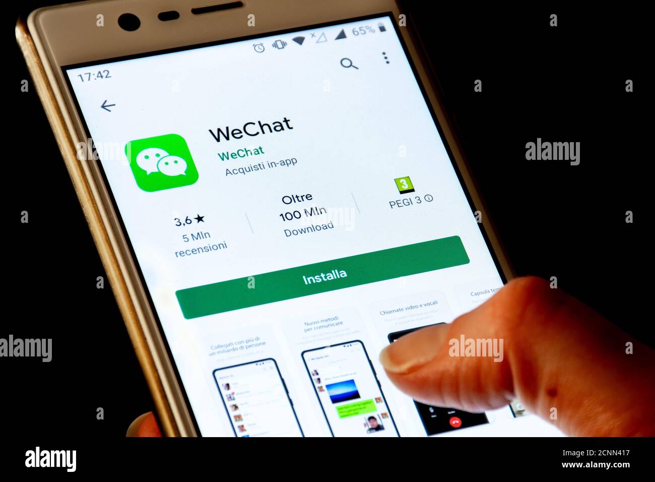 Gros plan du logo WeChat, icône d'application affichée sur un smartphone avec le doigt, Trump interdit et bloqué le téléchargement aux États-Unis Banque D'Images