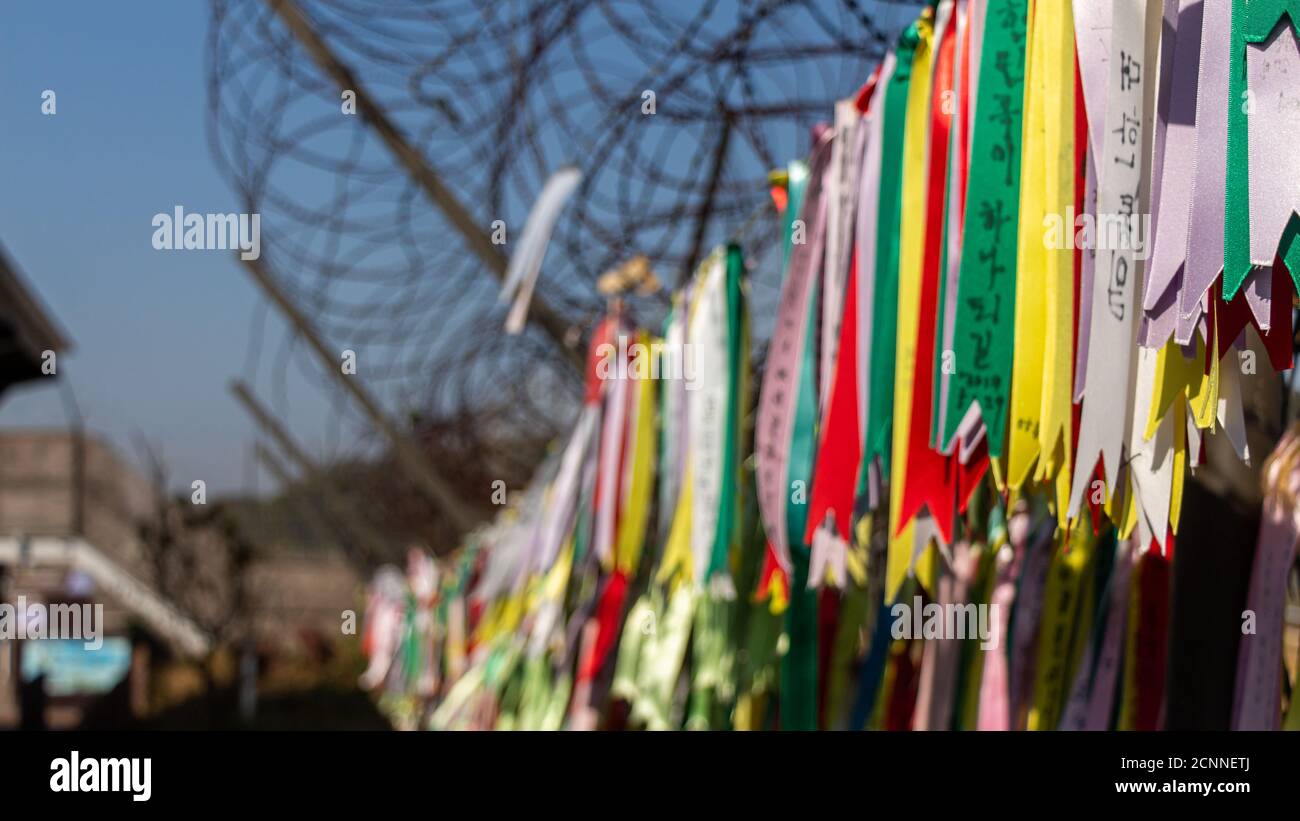 Rubans de prière attachés à une clôture en barbelés dans la zone démilitarisée coréenne, en Corée du Sud. Traduction: 'Paix' Banque D'Images