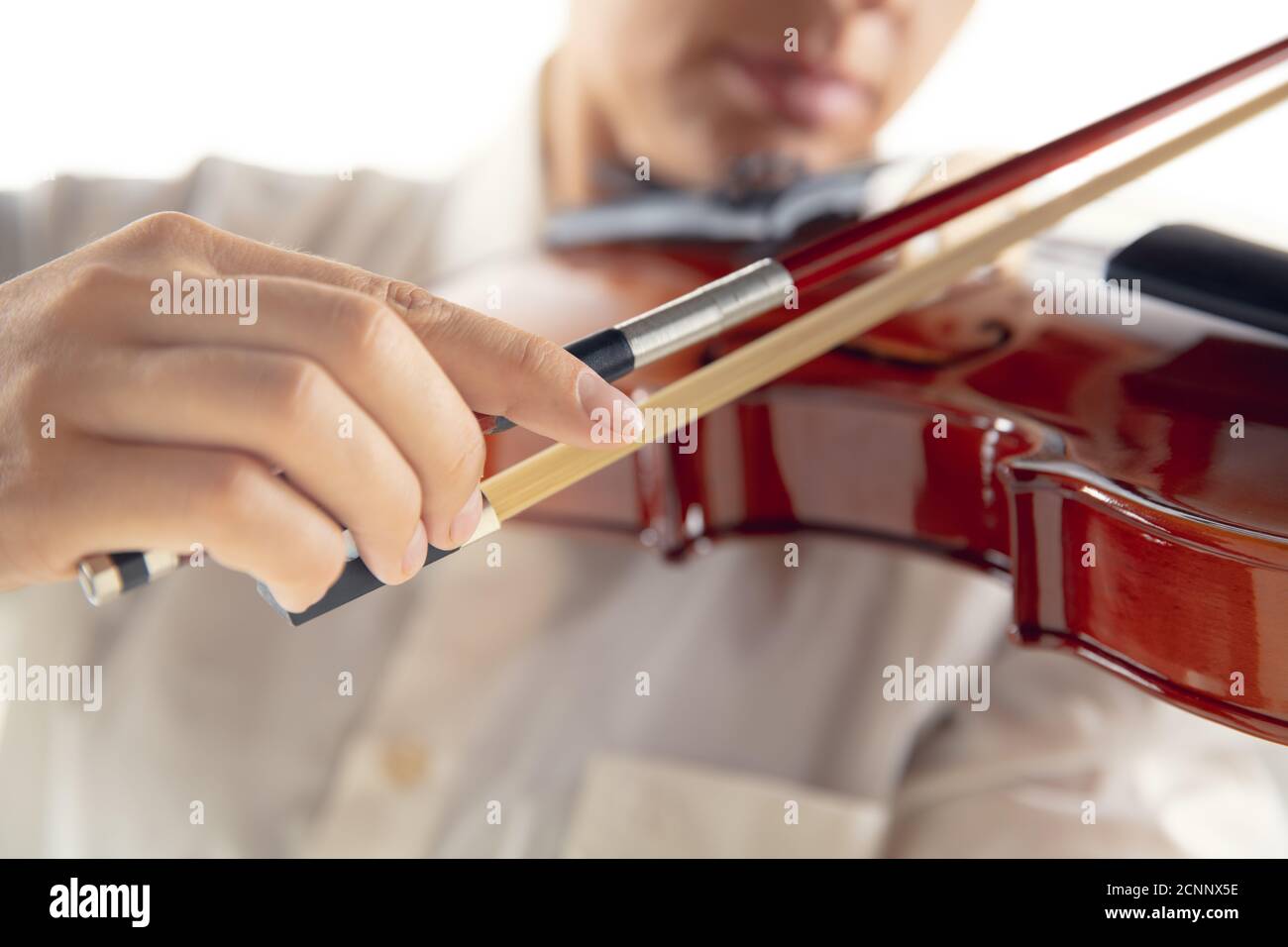 Femme en gros plan jouant du violon isolée sur fond blanc de studio. Musicien inspiré, détails de l'occupation de l'art, instrument classique du monde. Concept de passe-temps, créativité, inspiration. Banque D'Images