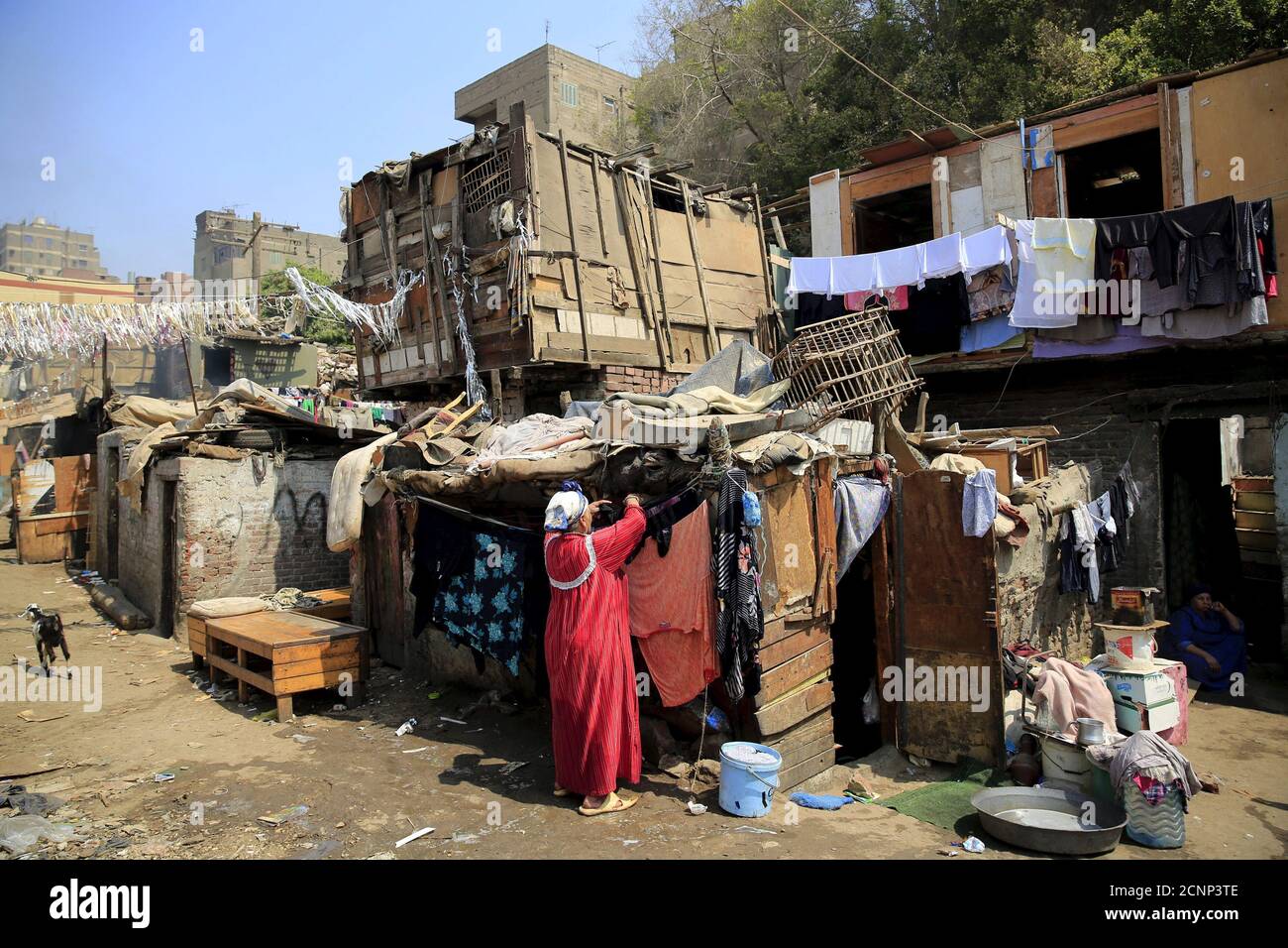 Une femme lave ses vêtements dans le bidonville d'Eshash el-Soudan, dans le  quartier Dokki de Gizeh, au sud du Caire, Égypte le 2 septembre 2015. Les  habitants du bidonville se sont affrontés