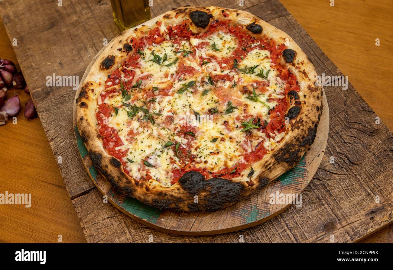 Pizza Margarita ou Margherita avec tomates, fromage mozzarella, sauce tomate et basilic. Pizza traditionnelle napoletana sur une table en bois Banque D'Images