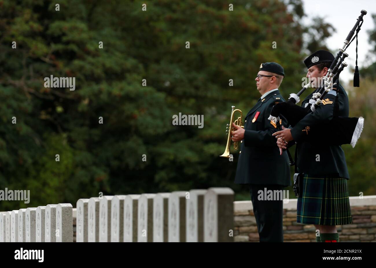 Un soldat joue les cornemuses lors de l'enterrement de quatre soldats  canadiens de la première Guerre mondiale au cimetière britannique Loos de  la Commission des sépultures de guerre du Commonwealth (CWGC), à
