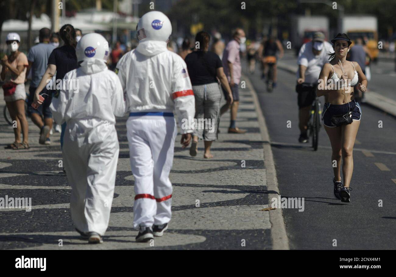 Tercio Galdino, 66 ans, et sa femme Alicia, 65 ans, portent leurs  combinaisons protectrices lorsqu'ils marchent sur le trottoir de la plage  de Copacabana, au milieu de l'épidémie de coronavirus (COVID-19) à