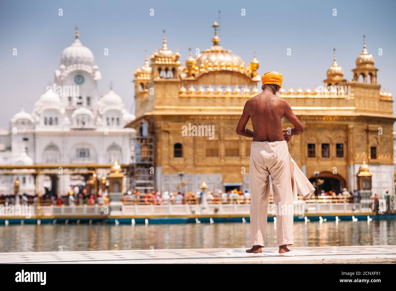 Sikh pèlerin en prépréparant à s'immerger dans le réservoir Saint près du Temple d'Or (Sri Harmandir Sahib), Amritsar Banque D'Images