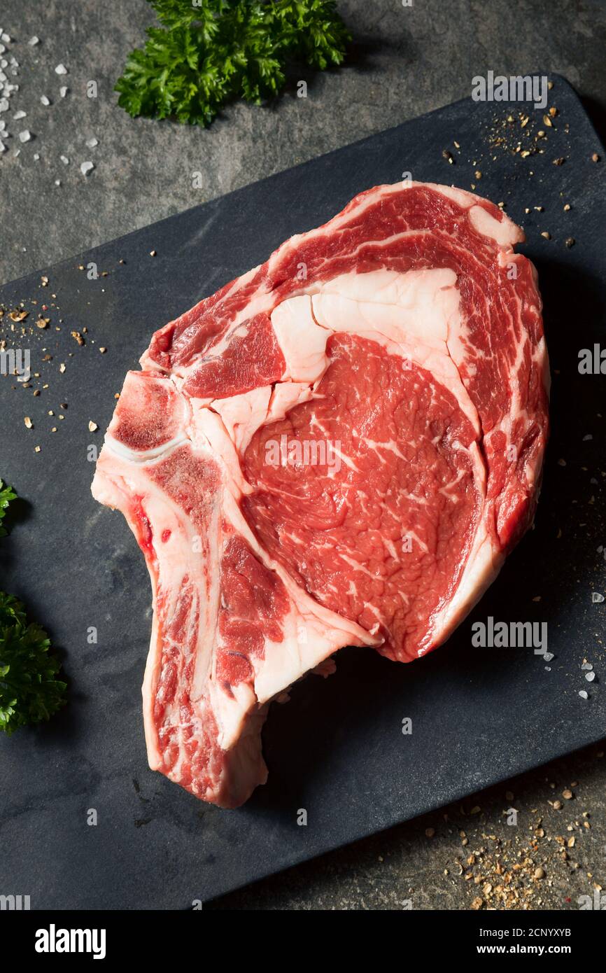 Steak de Ribeye à l'herbe crue avec sel et poivre Banque D'Images