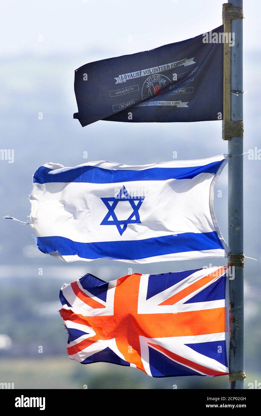 Le drapeau israélien vole haut dans les zones protestantes loyalistes du nord de Belfast, le 15 août 2002, tandis que les drapeaux palestiniens sont volées dans les zones catholiques de la ville. De nouvelles peintures murales hautes en couleurs, républicaines et palestiniennes, sont apparues récemment sur les murs de l'ouest de Belfast, en Irlande du Nord, pour soutenir la crise du Moyen-Orient. REUTERS/Paul McErlane PM/AH Banque D'Images