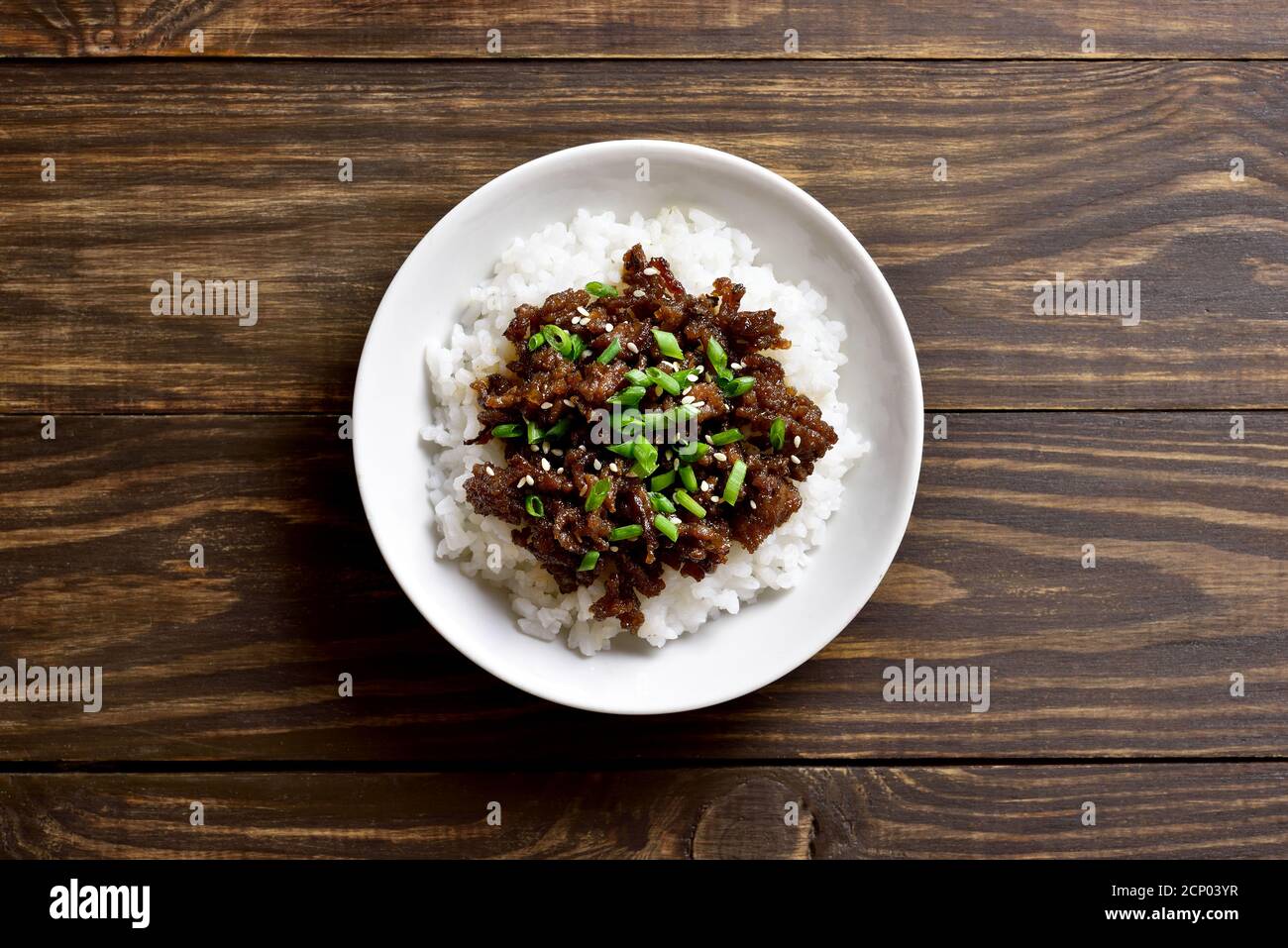 Bol à riz et bœuf moussé coréen sur fond de bois avec espace de texte libre. Vue de dessus, plan d'appartement Banque D'Images