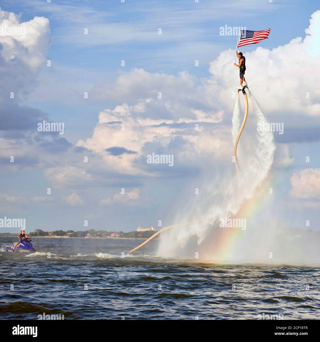Homme de roquette volant sur un Jet Fly Board au lac Arlington, Texas et tenant un drapeau américain. Banque D'Images