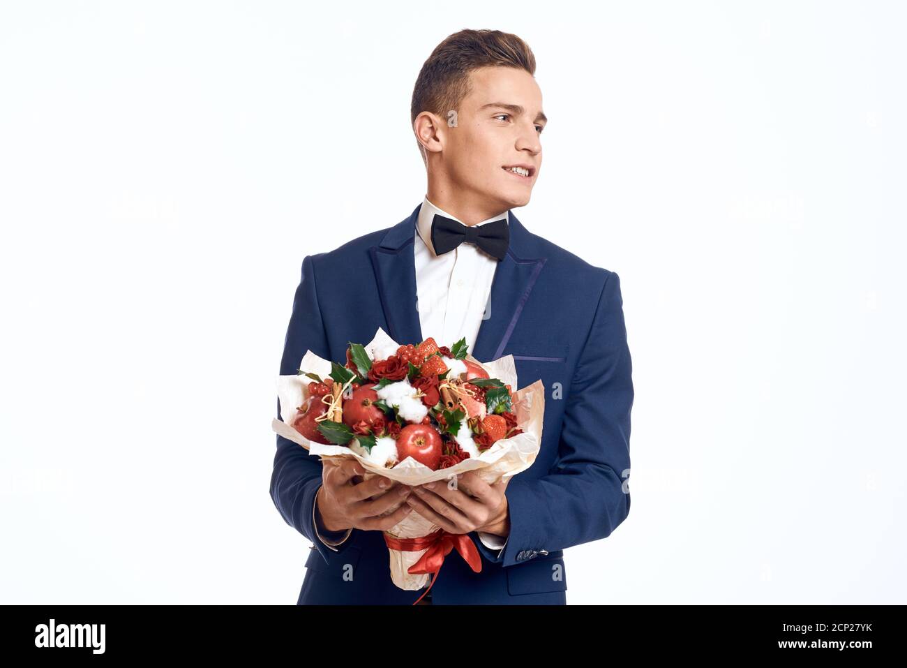 Un homme élégant dans un costume classique orné d'un noeud cravate tient un  bouquet de fleurs dans sa main Photo Stock - Alamy