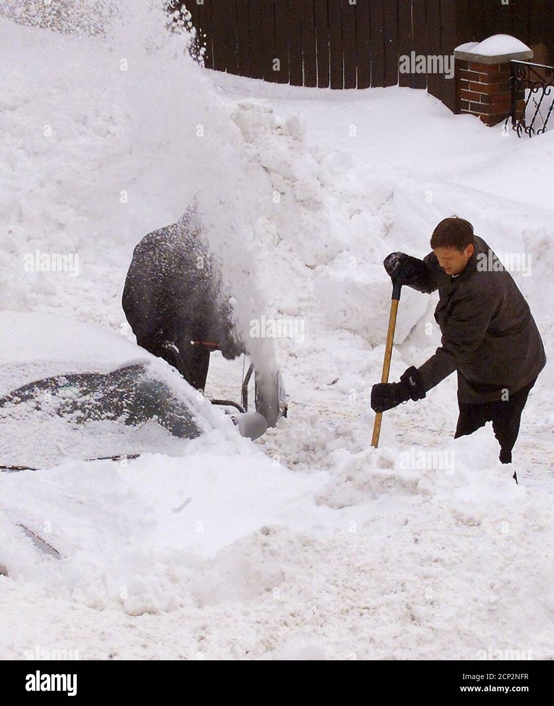 Les habitants de la banlieue de Boston, Medford, Massachusetts, creusent leurs voitures hors de la neige le 18 février 2003 après un blizzard important a frappé la région de Boston. La tempête lente a déversé plus de 27 pouces de neige sur Boston alors qu'elle terminait sa marche sur la côte est des États-Unis, des Carolinas à la Nouvelle-Angleterre, fermant la plupart de la région pendant plusieurs jours. REUTERS/Jim Bourg JRB Banque D'Images