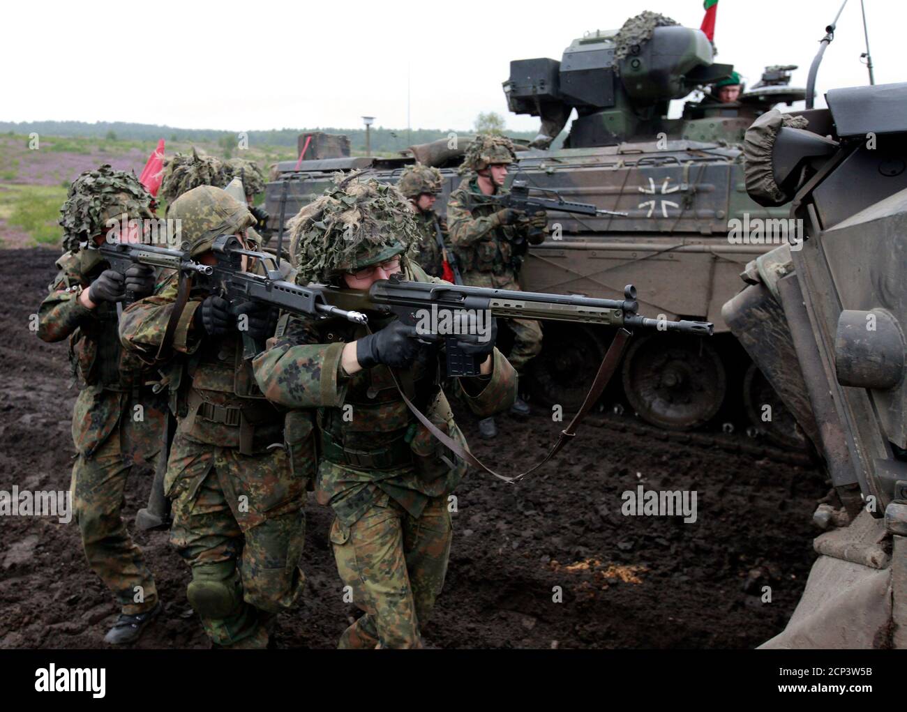 German Bundeswehr armed forces soldiers of the 62th mechanized infantry  battalion take position next to a "Marder" armoured personnel carrier (APC)  during a military exercise in the northern German town of Bergen,