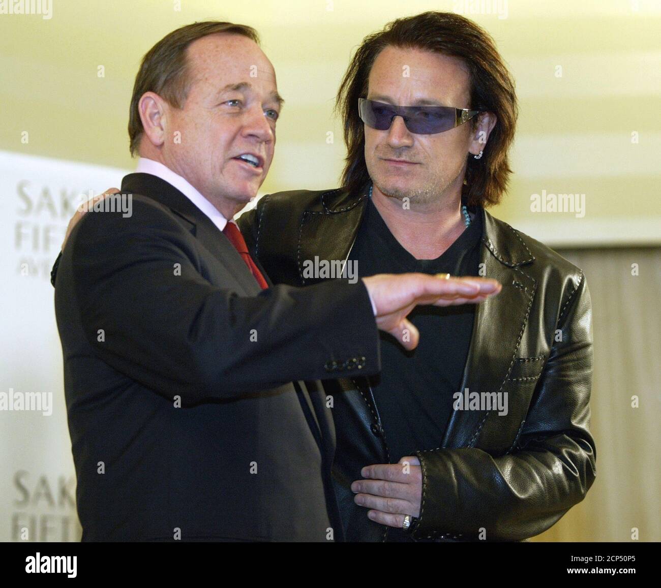 U2 singer Bono (R) talks to reporters with Fred Wilson, chairman and CEO of  Saks Fifth Avenue. at a news conference where Bono and his wife Ali Hewson  launched a new fashion