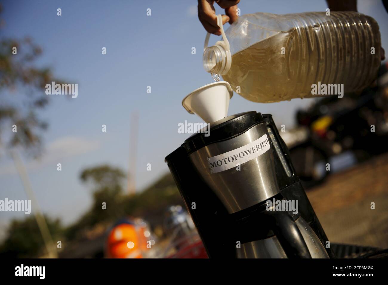Ricardo Azevedo filtre l'eau de la rivière Tiete polluée à l'aide d'un  filtre de café avant de remplir le réservoir de sa moto Honda NX 200 avec  elle à Salto, au nord-ouest
