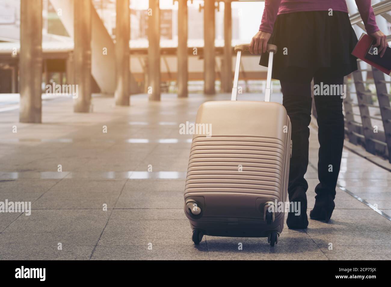 Femme voyageur avec sac de voyage ou bagages marchant dans le passage du terminal de l'aéroport pour voyager à l'étranger. Banque D'Images