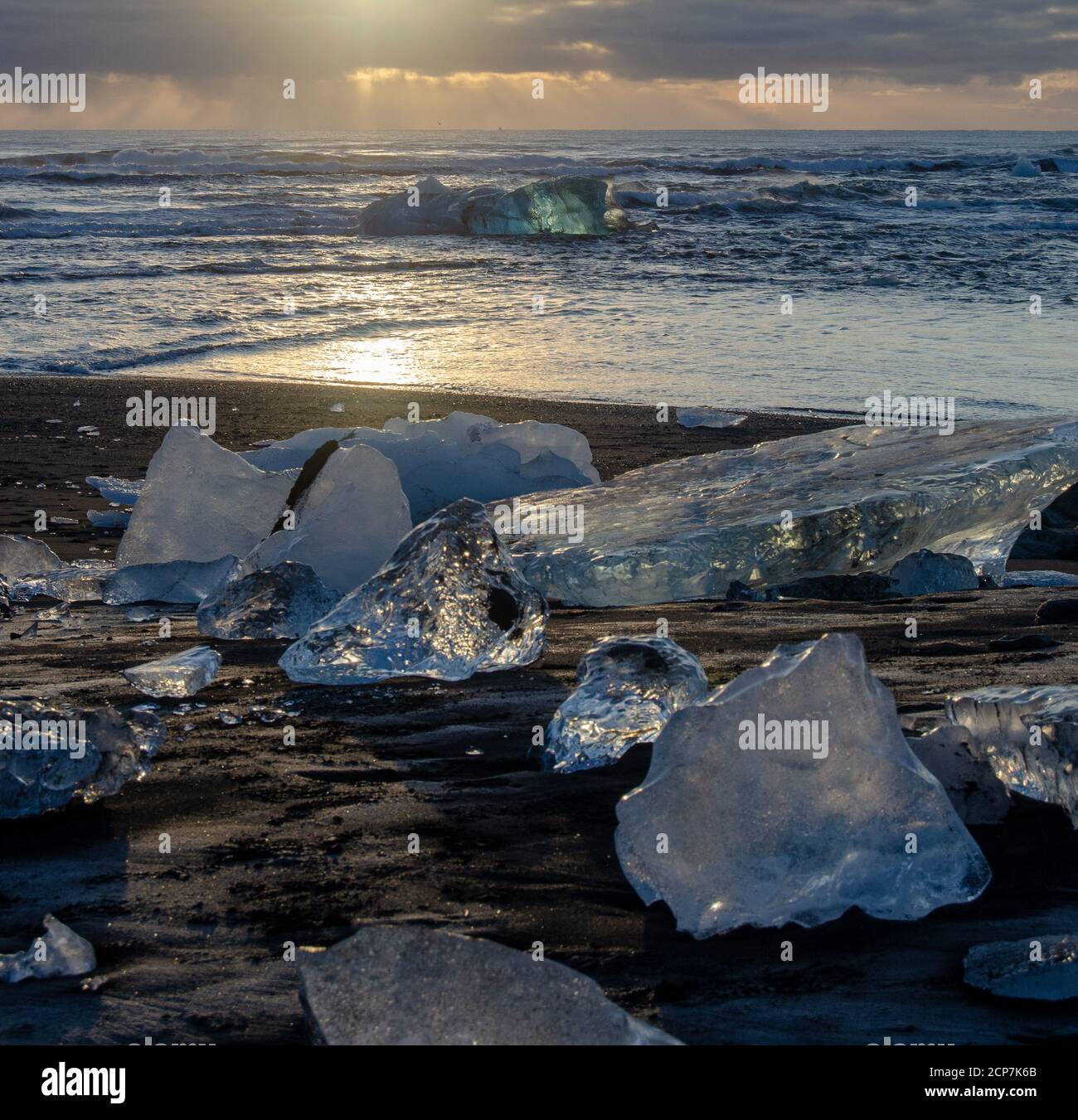 Lever de soleil sur Diamond Beach Islande, avec la lumière se reflétant dans les icebergs façonnés par les vagues de l'océan. Banque D'Images