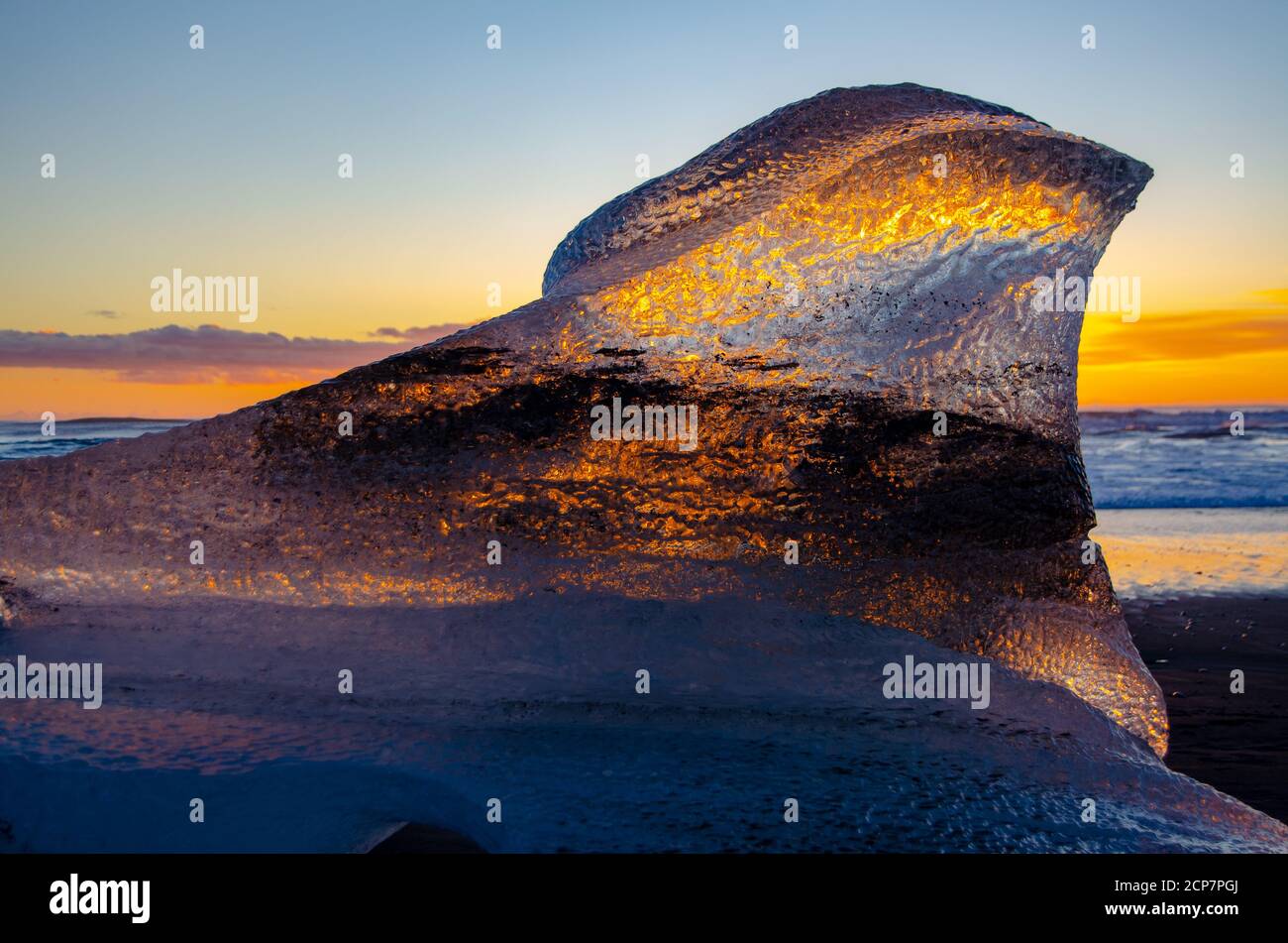 Lever de soleil sur Diamond Beach Islande, avec la lumière se reflétant dans les icebergs façonnés par les vagues de l'océan. Banque D'Images