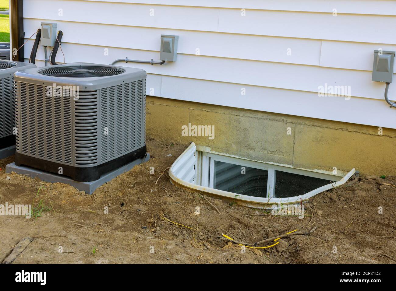 Système de climatisation assemblé lors de l'exécution de l'entretien préventif dans un puits de fenêtre pour la construction de sous-sol nouvelle maison résidentielle Banque D'Images