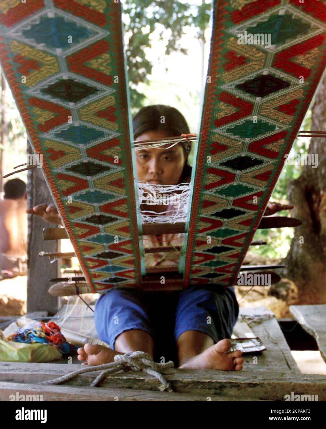 La tribesfemme philippine Ida Jamaani, 20 ans, délasse un tissu Yakan pour servir de taupe de prêtre au village de tissage Yakan dans la ville de Zamboanga, dans le sud des Philippines le 1er août 2000. Le village de tissage de Yakan a été une attraction touristique à Zamboanga, populaire pour ses tissus, mais le propriétaire dit "que l'enlèvement de touristes rampant dans toute Mindanao a coûté une vente à faible profit". Au moins 29 ressortissants étrangers pour la plupart sont encore pris en otage par le extrémiste musulman Abu Sayyaf dans leur cachette de Patikul, île de Sulu, dans le sud des Philippines. RR/HL Banque D'Images