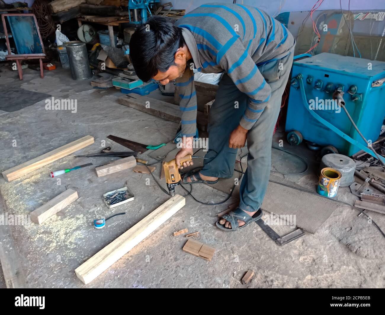 DISTRICT KATNI, INDE - 09 DÉCEMBRE 2019 : un ouvrier automobile indien de taille de bois dans un garage couvert. Banque D'Images