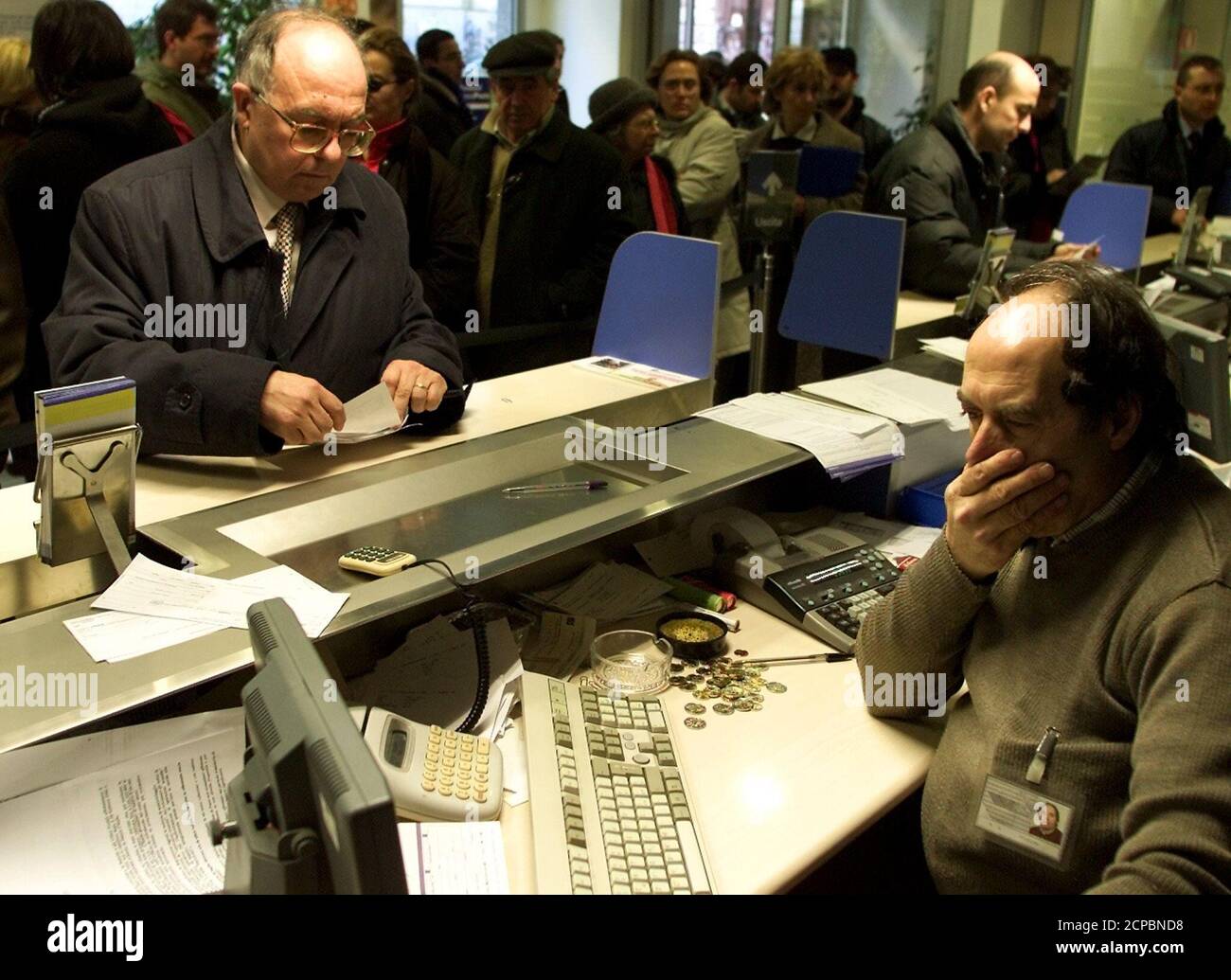Un caissier montre sa frustration alors qu'il tente d'établir les taux de  change entre l'euro et le lire dans un bureau de poste dans le centre de  Rome le 4 janvier 2002.