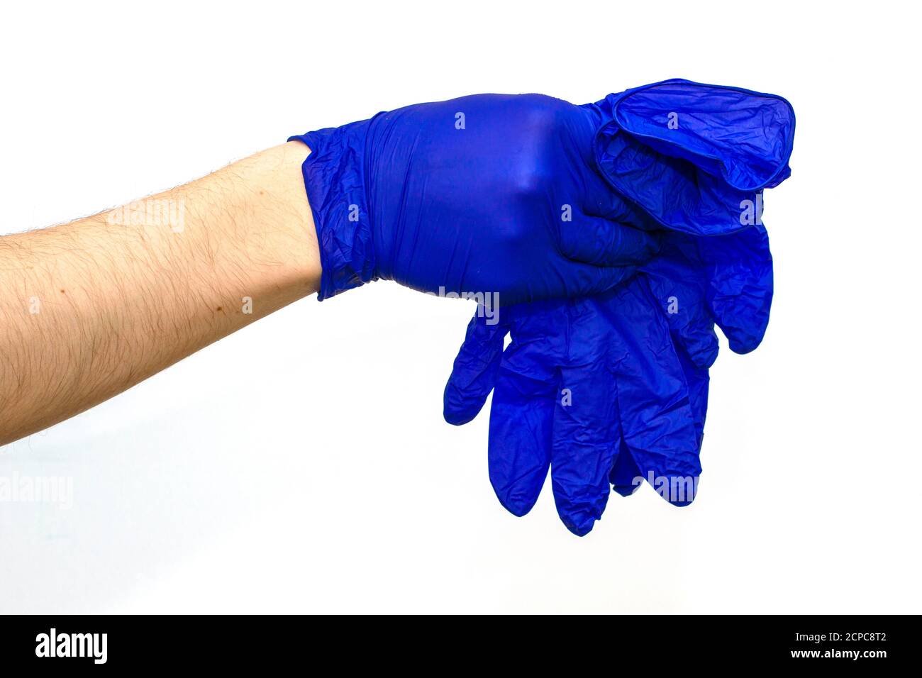 main dans un gant chirurgical de protection bleu se dérobant aux gants bleus sur fond blanc Banque D'Images