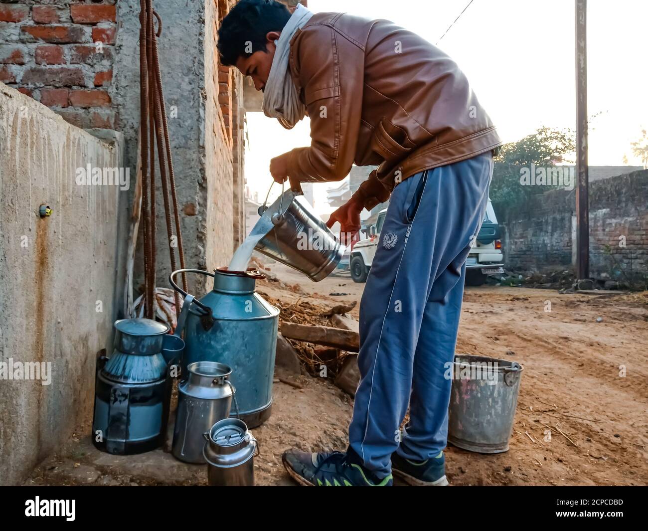 DISTRICT KATNI, INDE - le 04 JANVIER 2020 : un producteur laitier qui recueille du lait sur un contenant dans sa zone extérieure de ferme laitière locale, une scène agricole indienne. Banque D'Images