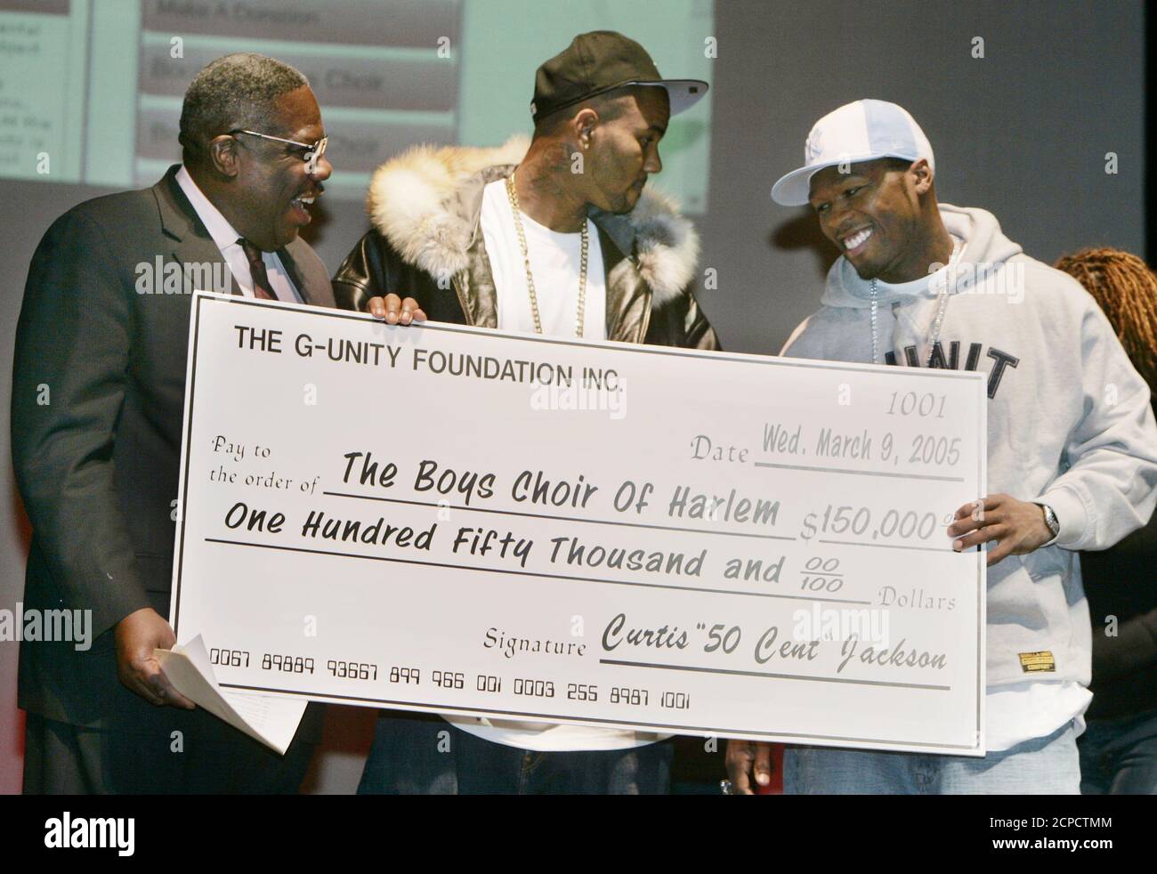 Rappers 50 Cent R And The Game C Hold Oversize Checks After Making Donations To The Boys Choir Of Harlem And The Compton Unified School District Music Program As Part Of An
