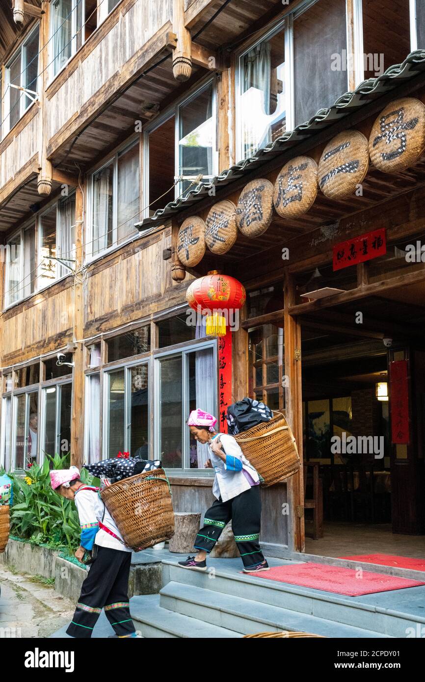 Les femmes portant les bagages du touriste à Ping'an. Banque D'Images