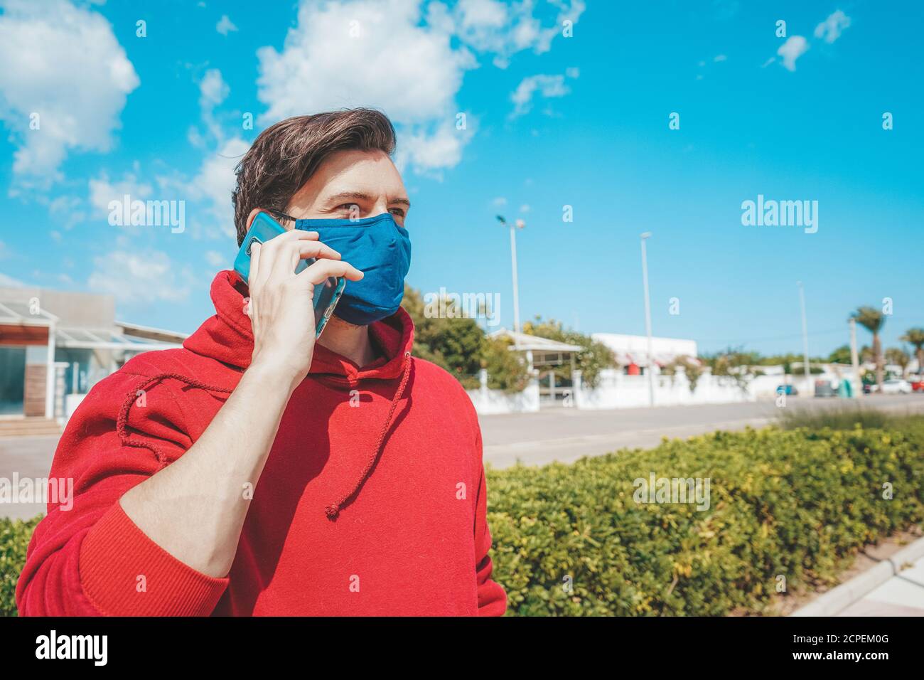 Hommes utilisant son smartphone avec un masque facial en Espagne Banque D'Images