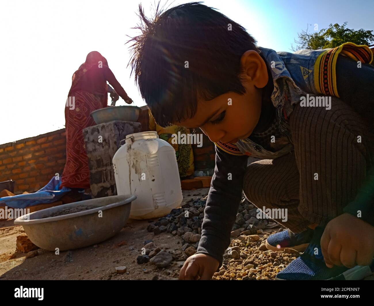 DISTRICT KATNI, INDE - le 13 JANVIER 2020 : un enfant indien de sexe masculin assis sur le chantier de construction en fond de ciel. Banque D'Images