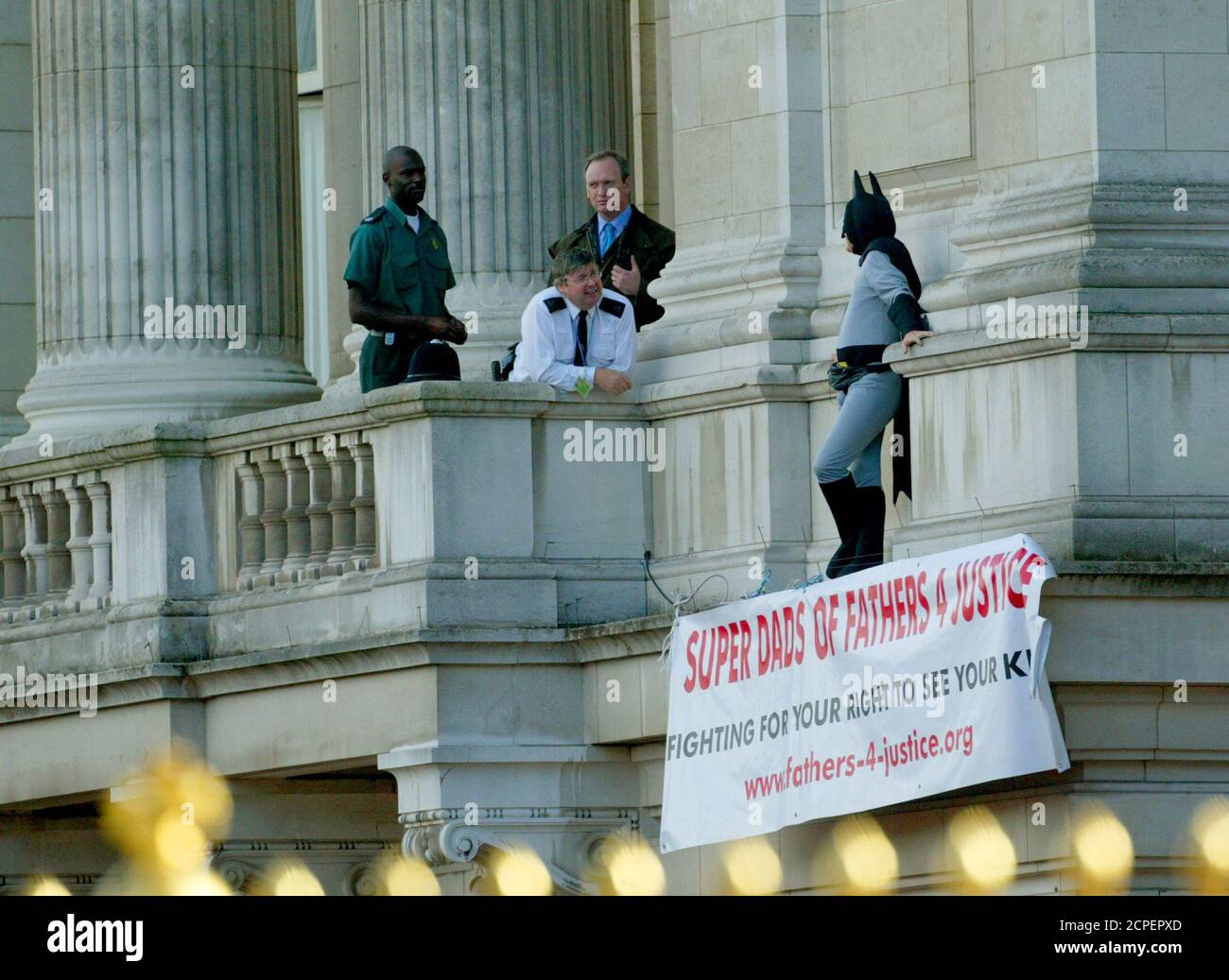 Security officers standby as father's rights campaigner Jason Hatch (R),  dressed as Batman, protests on a balcony at Buckingham Palace in London,  September 13, 2004. Hatch from the fathers' rights group that